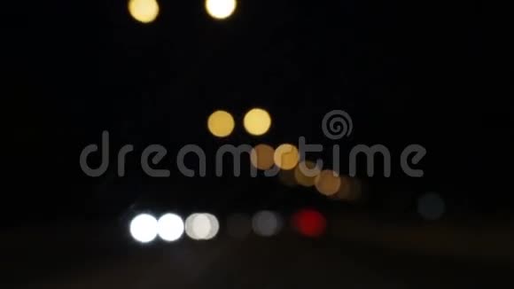 晚上开车黑暗中汽车灯光的挡风玻璃视图城市街道上的交通信号灯摘要背景视频的预览图