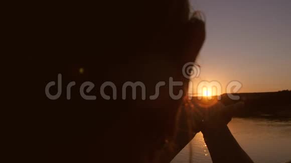 女孩在夕阳下抱着红太阳视频的预览图