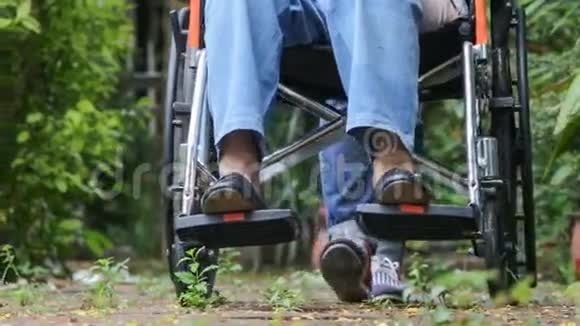 轮椅上的老年妇女与照顾者一起行走视频的预览图