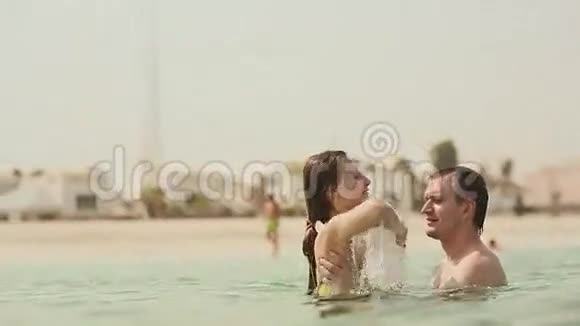 男孩和女孩快乐地在海里游泳视频的预览图