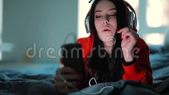 躺在床上听耳机音乐的女孩视频的预览图