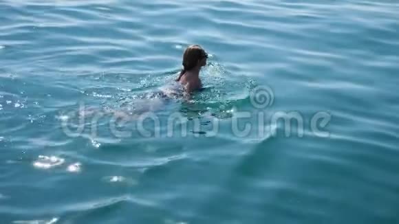 金发美女在开阔的大海里享受着水漂浮着从上面看慢动作视频的预览图