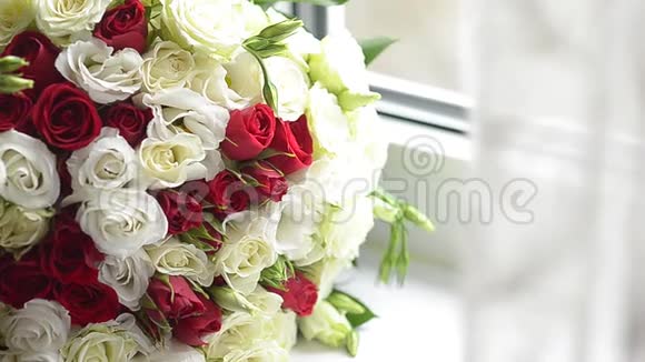 窗前摆着一束红白相间的玫瑰花桌上摆着美丽的五颜六色的花视频的预览图