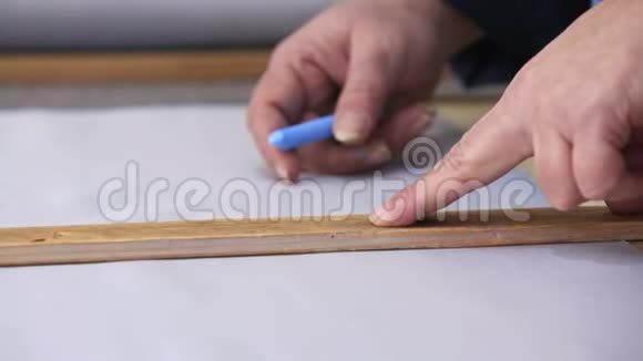 在一家家具厂里一位年长的妇女正在用一个衬衫为沙发测量和标记一种灰色材料视频的预览图