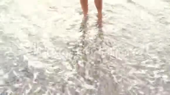 沙滩上晒黑的女性腿沙滩上的海水溅在脚上视频的预览图