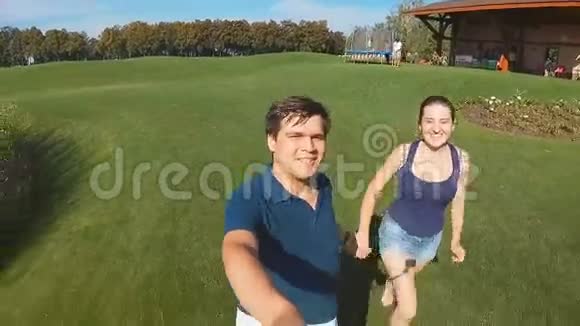 快乐的年轻夫妇牵着手在公园跑步视频的预览图