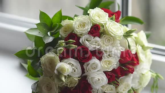 窗前摆着一束红白相间的玫瑰花人们手里拿着美丽的五颜六色的花视频的预览图