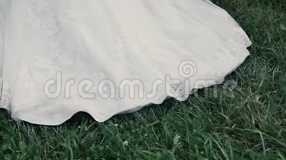 结婚礼服新娘在草地上散步视频的预览图