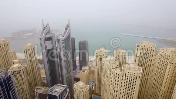 鸟瞰摩天大楼的阵列面对大海在小雾阿拉伯联合酋长国迪拜视频的预览图