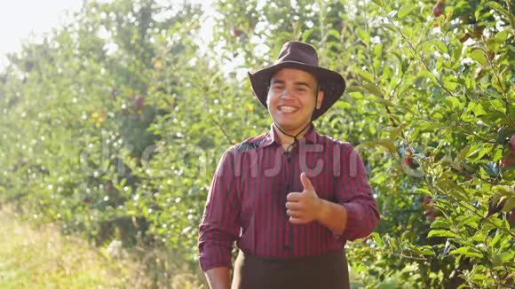 农夫站在花园里举起一双大手指的画像视频的预览图