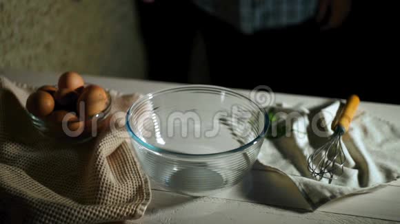 男人的手在碗里打碎鸡蛋厨师用玻璃碗打碎鸡蛋视频的预览图