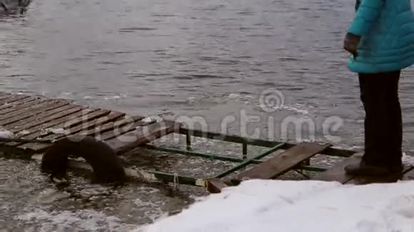 一个女人在冰封的码头上危险地行走视频的预览图