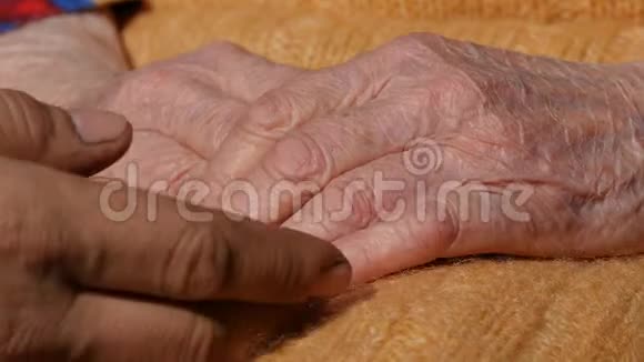 一个年轻肮脏的工人她的手安慰着一双老奶奶的手视频的预览图