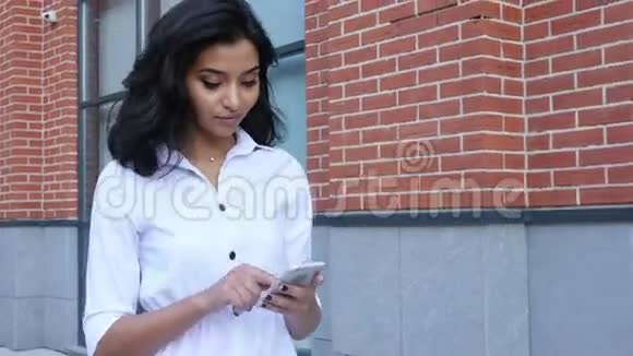 智能手机和户外行走的女孩短信视频的预览图