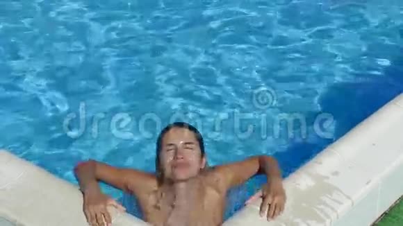 有魅力的女孩在游泳池里的摄像机上摆着身体姿势慢动作视频的预览图