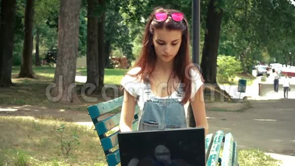 戴戴眼镜的年轻女孩手提电脑上的指纹视频的预览图