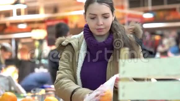 一位年轻女子在超市里挑选橘子视频的预览图