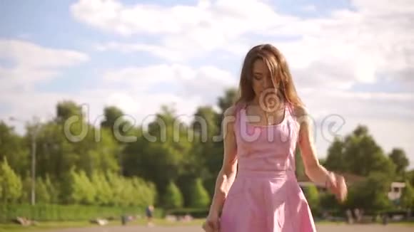 体贴的黑发女孩穿着粉红色的裙子在镜头前散步慢动作安定夹视频的预览图