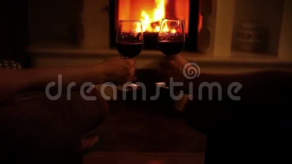 浪漫的一对夫妇晚上在壁炉旁舒适的家里喝杯葡萄酒视频的预览图