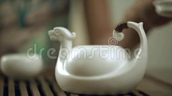 女用手在茶壶杯里泡茶把茶壶里的泡茶关上视频的预览图