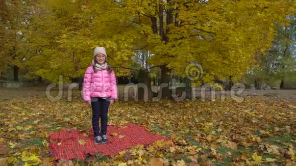 女孩坐在一个巨大的分割摆姿势在秋天公园视频的预览图