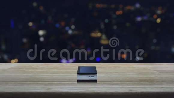 木制桌子上的现代智能手机屏幕上的问号标志图标模糊的彩色夜光城市塔和摩天大楼视频的预览图