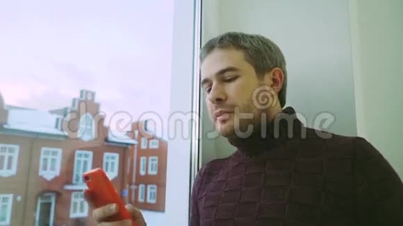 穿着毛衣的帅哥在检查他的计划并打电话视频的预览图