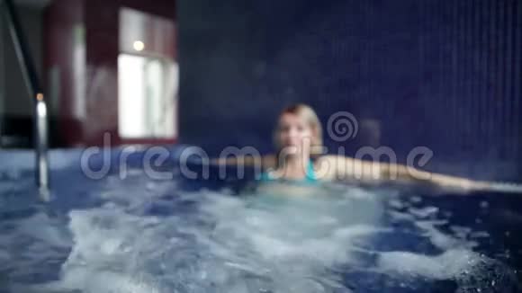 穿着蓝色比基尼在游泳池里锻炼脚的年轻女子视频的预览图