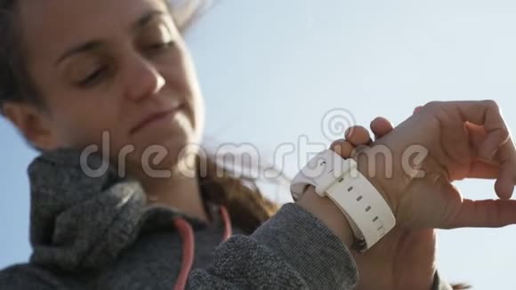 在海滩上使用智能运动跑步手表的贴身女士视频的预览图