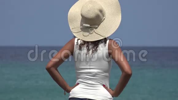夏天在海洋附近戴帽子的女人视频的预览图
