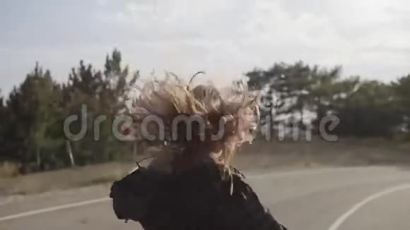 快乐的女孩沿着城外的车道走着大树枝笑着视频的预览图