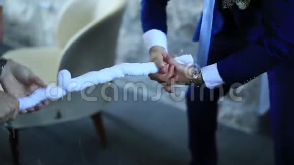 穿夹克的男人拧毛巾俄罗斯婚礼比赛视频的预览图