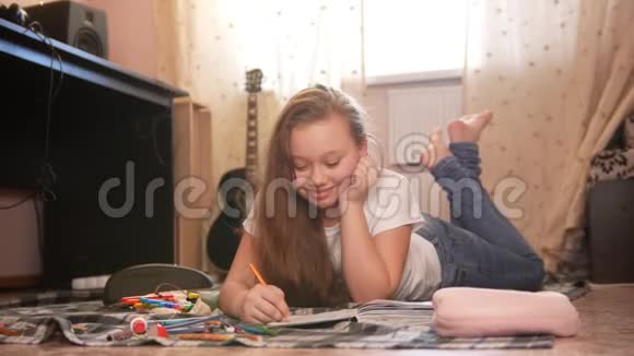 一个女孩她躺在地上在家画画视频的预览图