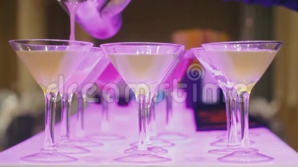 酒保把一杯饮料倒入玻璃杯中使酒壶发光视频的预览图