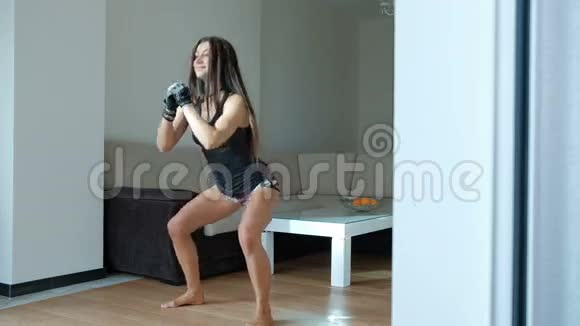 健身教练女子蹲在室内客厅视频的预览图