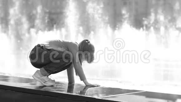 在城市里的一个夏天喷泉附近的一个孩子在玩水视频的预览图
