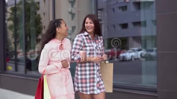 两个女孩拿着购物袋去购物后慢动作视频的预览图