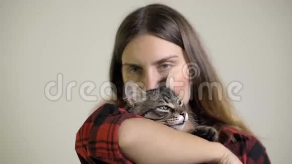 女人关心喜欢吻一只小猫在她的膝上视频的预览图