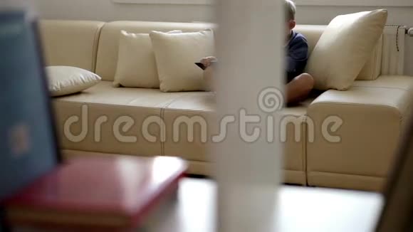 一个坐在沙发上看书的男孩正在偷窥镜头视频的预览图