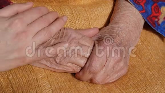 一个年轻男人和女人的手安慰着户外祖母的一双旧手视频的预览图