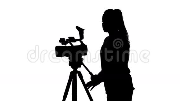 视频导演在演播室里管理一台专业的摄像机白色的剪影视频的预览图