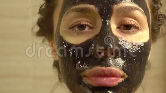 漂亮的年轻女人脸上戴着化妆品黑色的脸包K4关闭视频的预览图