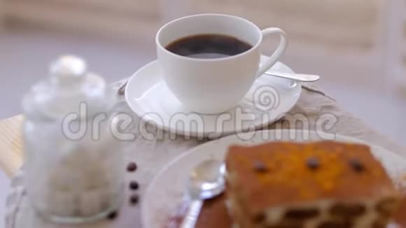 自制意大利甜点提拉米苏和靠窗的桌子上的咖啡视频的预览图