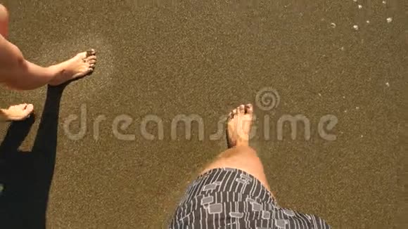 一对情侣一男一女用脚在湿漉漉的沙心上心被海浪冲走了一对夫妇视频的预览图