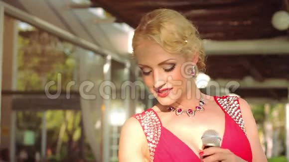 美丽的女歌手在户外穿红色裙子的肖像视频的预览图