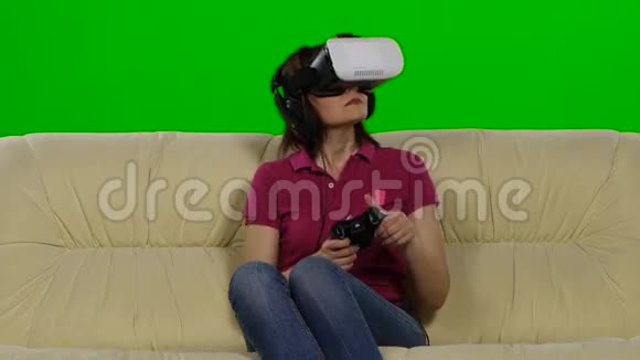 在沙发上戴虚拟现实眼镜的女人绿色屏幕视频的预览图