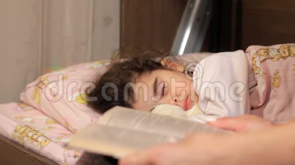那个女人给女儿读了一晚上的书那个女孩在看书下睡着了童话故事的故事视频的预览图