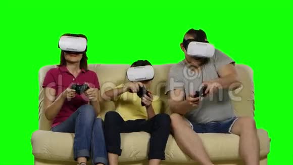 家人在玩虚拟面具的游戏中坐在沙发上绿色屏幕视频的预览图
