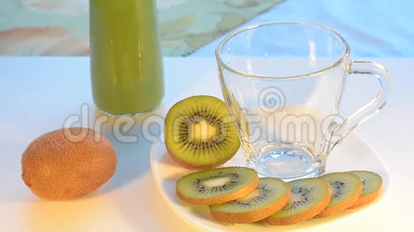 猕猴桃汁倒入一个杯子里一块块水果放在盘子里有选择的焦点视频的预览图