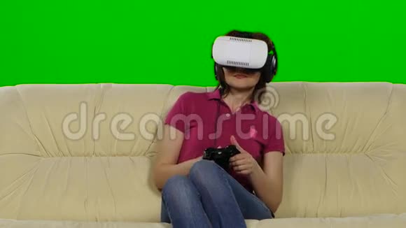 在沙发上戴虚拟现实眼镜的女人绿色屏幕关门视频的预览图